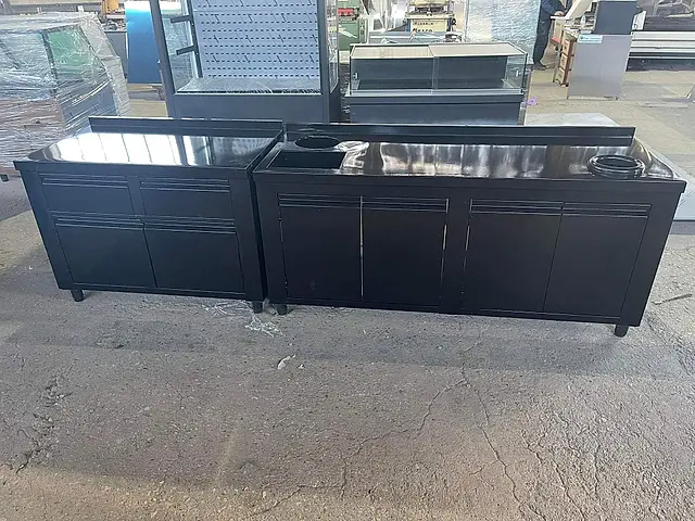 Cafe bar: Black counters with sink and waste chute