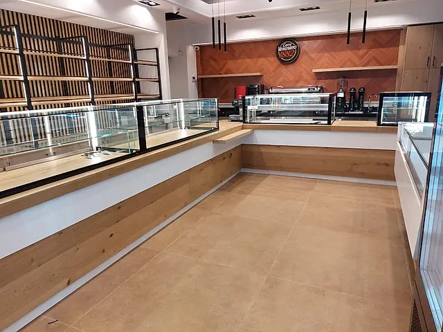 Bakery: Corner counter with display cases and coffee station